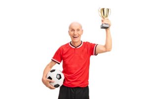 Senior football player holding a trophy and celebrating